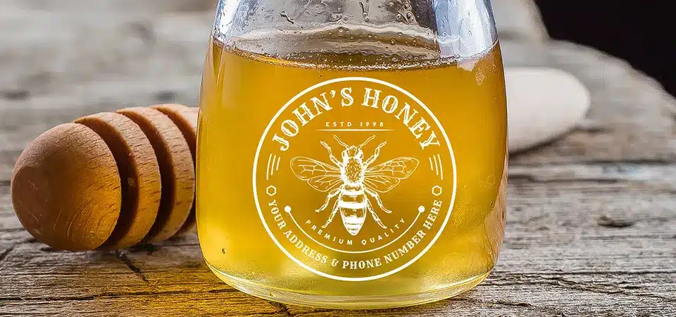 A clear label on a glass jar of honey, showcasing the honey's golden color.