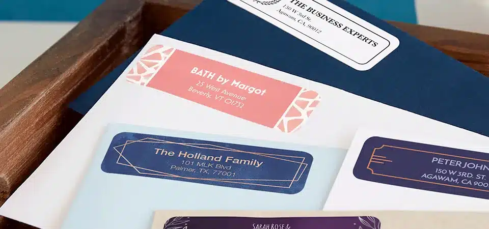 A roll of branded return address labels next to a stack of shipping boxes.