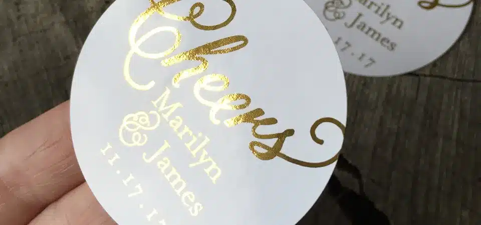 A customer's hand reaching for a product with a foil label on a crowded store shelf.