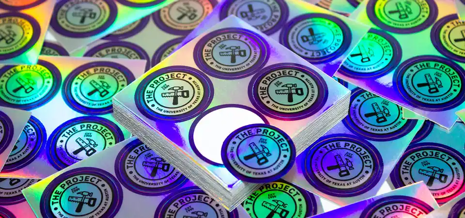 An image comparing a holographic, glitter, and a simple silver metallic sticker side-by-side.