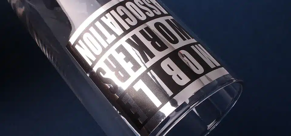 A mirror silver sticker on a product, clearly reflecting the user's hand and phone.