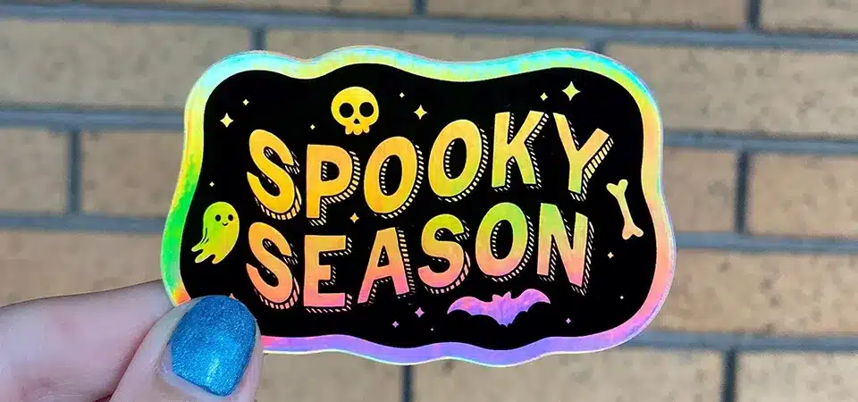 A close-up shot of a holographic sticker showing the smooth surface and shifting rainbow colors.