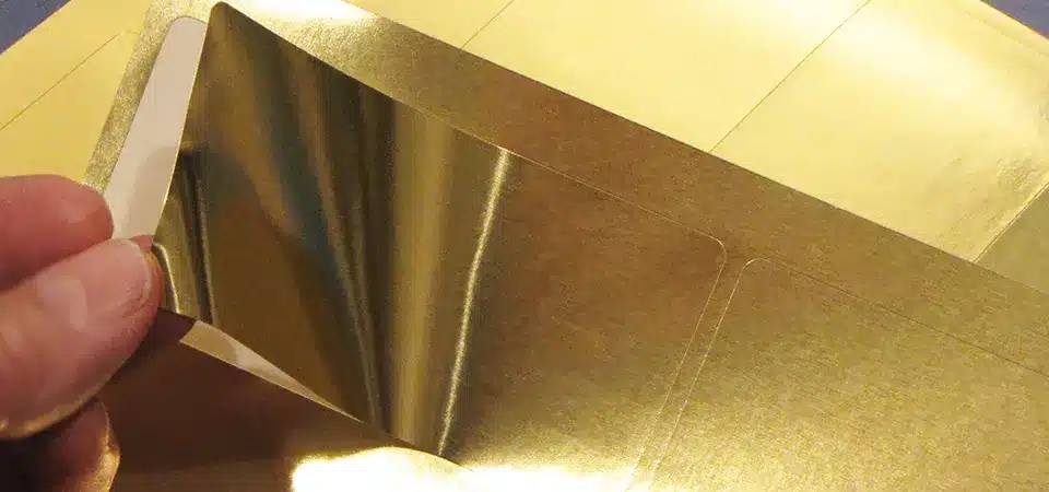 Foil printing being applied to different materials like smooth paper and vinyl.