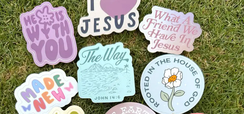 A hand holding several cool, custom die-cut individual stickers.