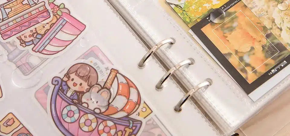 A school binder with a colorful sticker collage visible through its clear front sleeve
