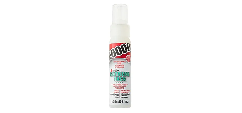 A bottle of repositionable glue being applied to the back of a wall decal