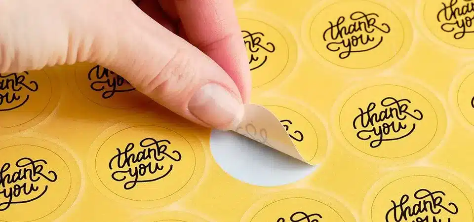 A close-up of a 2-inch circle sticker sealing a paper bag