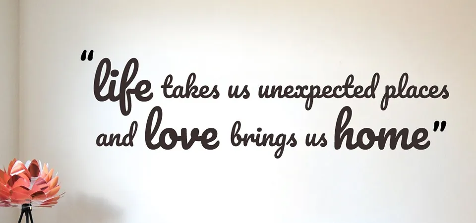 A hand easily peeling and sticking a wall sticker next to a hand using a squeegee on a wall decal