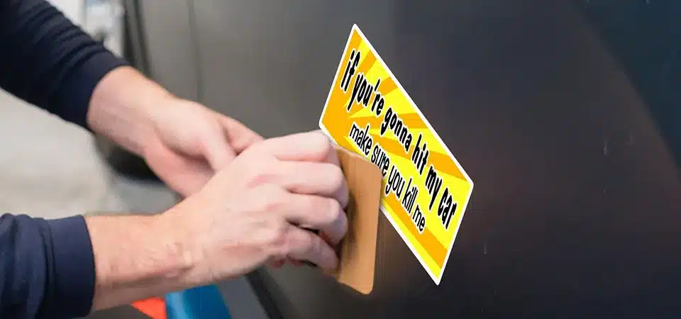 A hand in a glove cleaning a car door with an isopropyl alcohol wipe