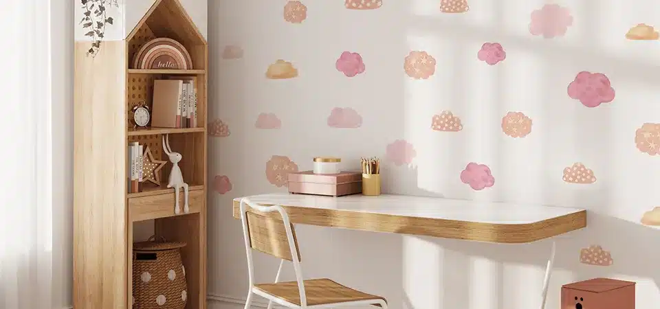 A person using a hairdryer to warm a sticker before peeling it from a wall