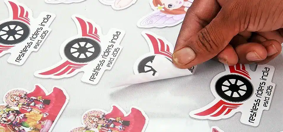 A digital printing machine processing a short roll of different sticker designs