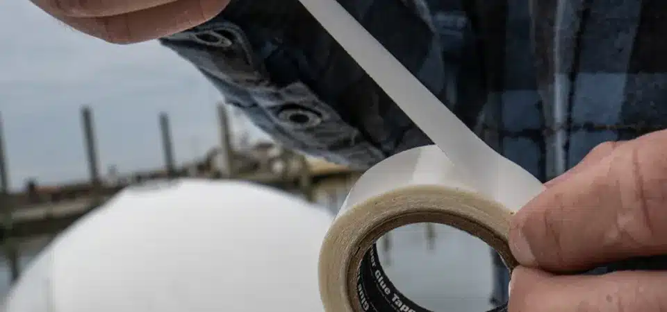 A roll of clear double-sided tape and a sticker ready for application