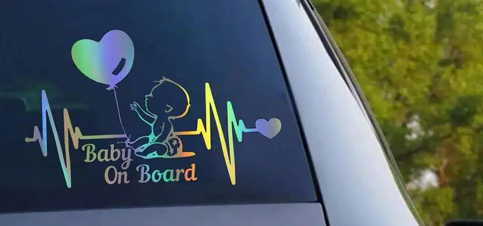 A close-up diagram showing the layers of a durable car sticker: laminate, ink, and vinyl