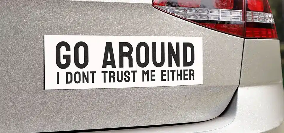 A colorful printed car sticker next to a single-color cut vinyl decal