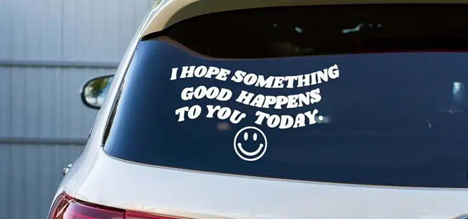 A car with a sticker on the door safely going through a touchless car wash