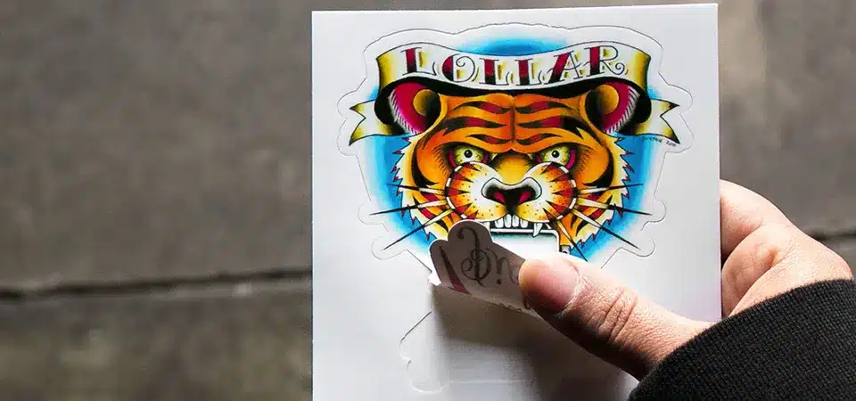 An image of a ruler next to a kiss cut sticker, measuring the 3x3 inch backing paper while the peelable sticker inside measures 2.7 inches