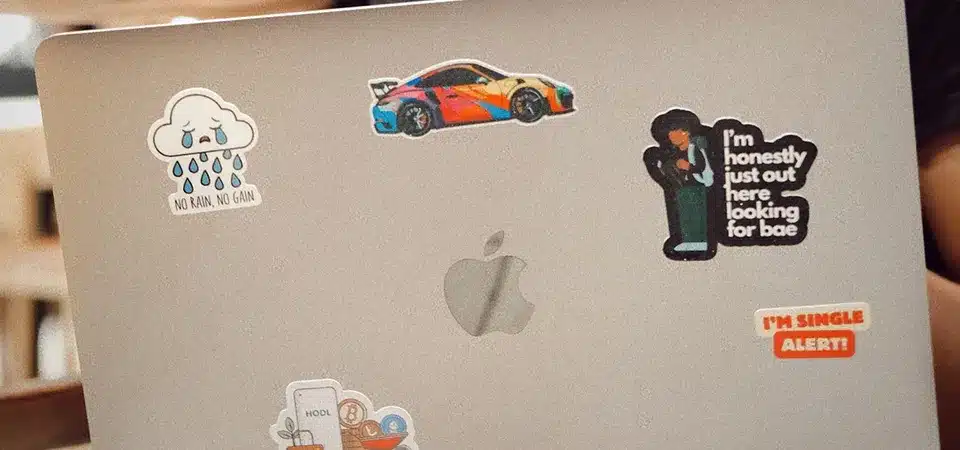 A hand using a microfiber cloth and alcohol to clean residue off a laptop