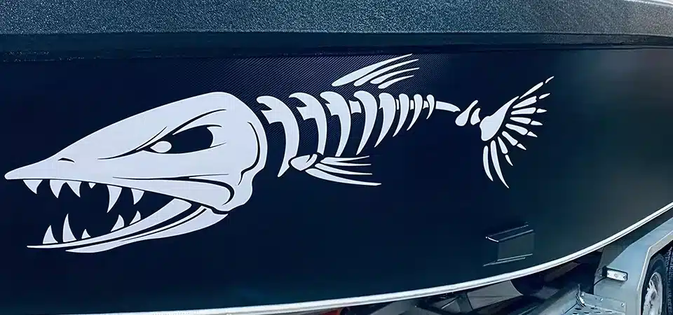 A person washing the side of a boat before starting to remove a decal