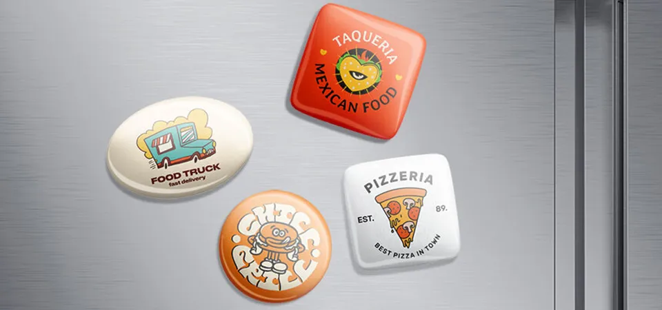 A close-up of a well-designed, die-cut logo magnet with a premium matte finish on a stainless steel fridge