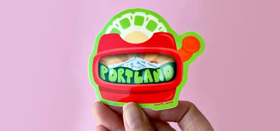 A sticker being carefully covered with a piece of wide, clear packing tape