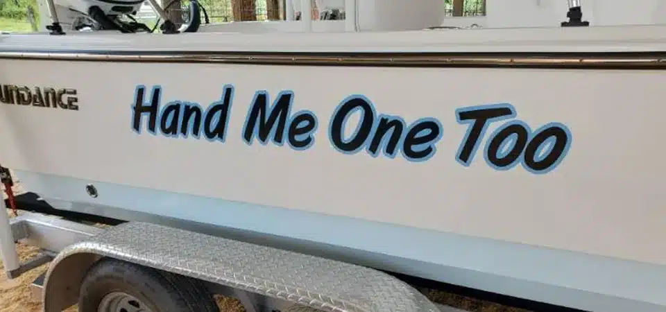 A hand applying a coat of wax to a freshly cleaned and polished boat hull