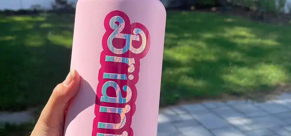 A hand using a squeegee to carefully apply a vinyl sticker to a clean surface