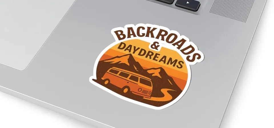 A closeup of a hair dryer warming a sticker on a laptop