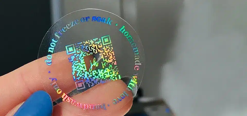 A diagram showing a back-adhesive sticker on a laptop and a front-adhesive sticker on the inside of a car window
