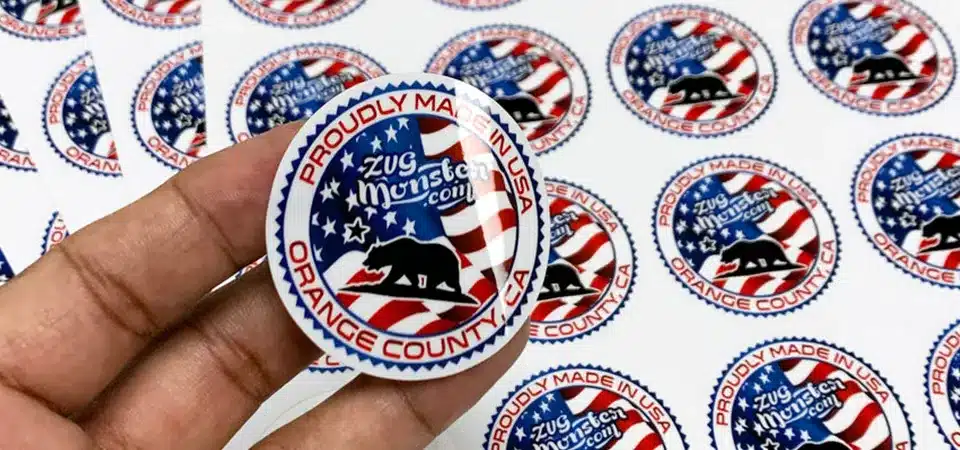 Applying Laminate to Stickers A machine applying a clear laminate film over a sheet of printed vinyl stickers