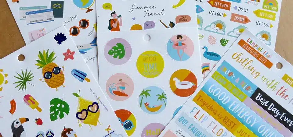 A travel-themed sticker sheet with world landmarks, a suitcase, and a camera