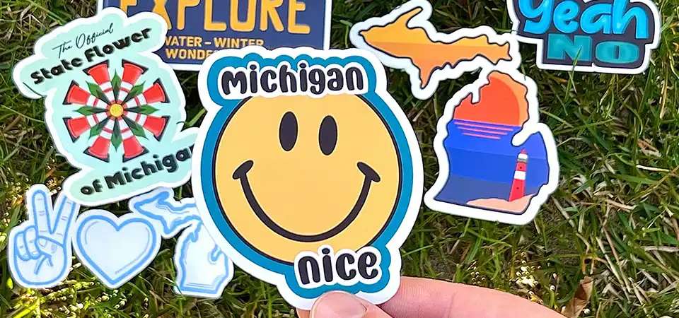 A close-up shot of rolls of vinyl, polypropylene, and polyester sticker materials