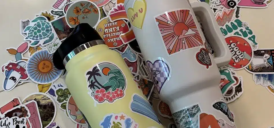 A diagram showing the different layers of a sticker: laminate, ink, vinyl, adhesive, and backing