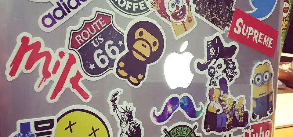 A vinyl sticker being peeled cleanly off a laptop, leaving no residue behind