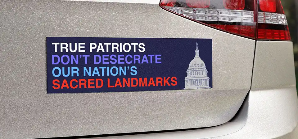 A campaign sticker on a laptop next to a coffee cup at a cafe