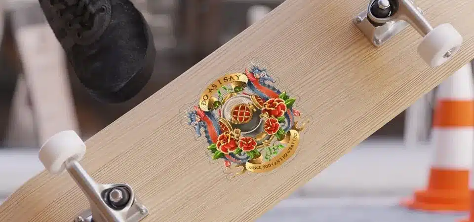 A person using a foam brush to apply a thin layer of Mod Podge over a sticker on wood