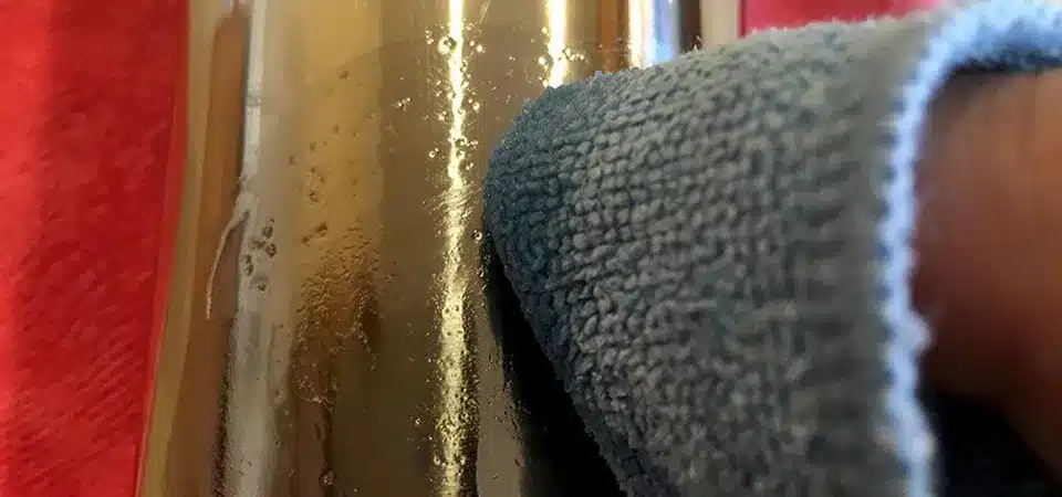 Mixing a baking soda and oil paste for sticker removal A small bowl with a paste made from baking soda and oil next to a metal surface with residue