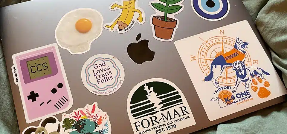 A close-up of a high-quality, die-cut vinyl sticker with a matte finish on a laptop surface