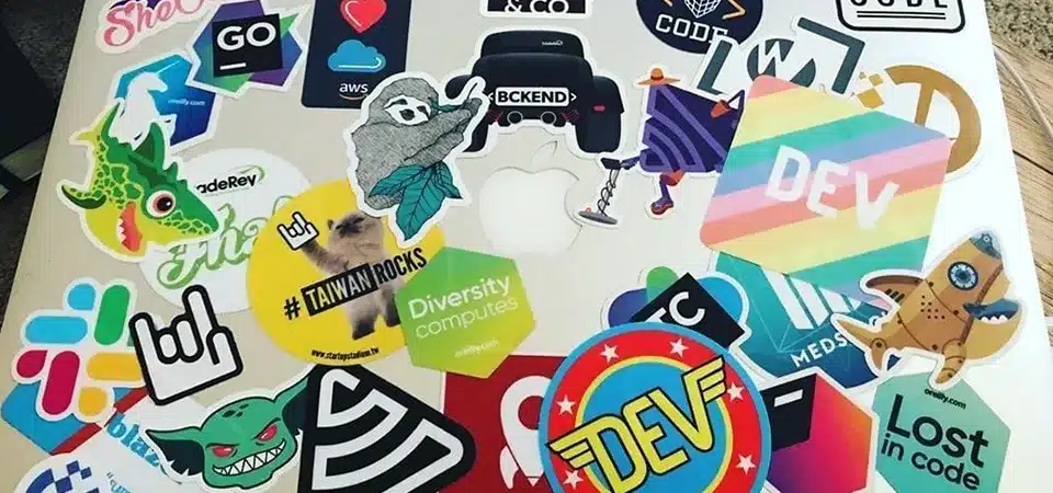 A close-up of an "Intel Core i7" sticker on a laptop next to a custom-printed logo sticker