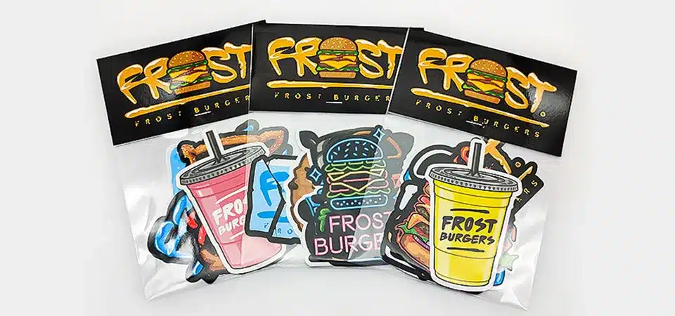 A collage of finished multi-design sticker packs, including cat illustrations and branded sticker sets