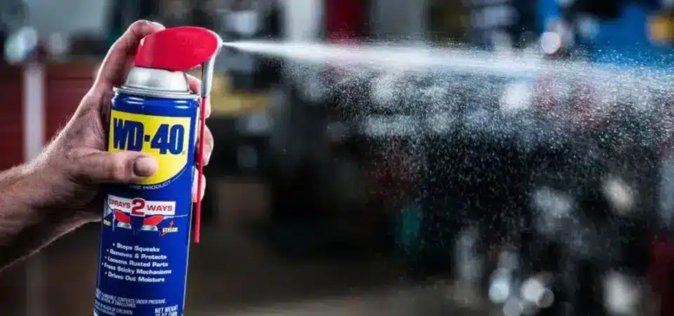 A person cautiously applying a commercial goo remover to a small spot of residue on furniture