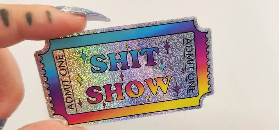 Washing a Waterproof Sticker A hand gently washing a sticker-covered water bottle in a sink with soap and water