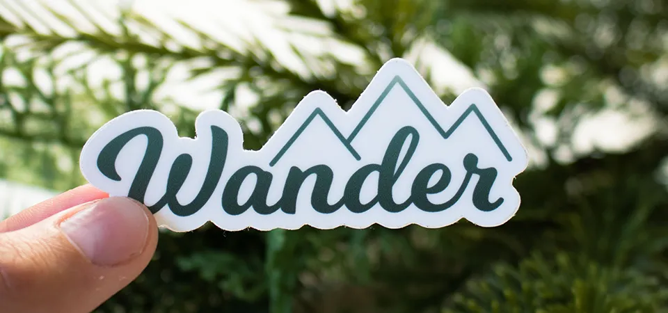 Outdoor vs. Indoor Sticker Lifespan A split image showing a vibrant sticker on an indoor laptop and a slightly faded sticker on an outdoor mailbox