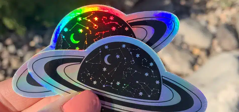 A holographic sticker with a rocket ship and the text 'To the moon and back'
