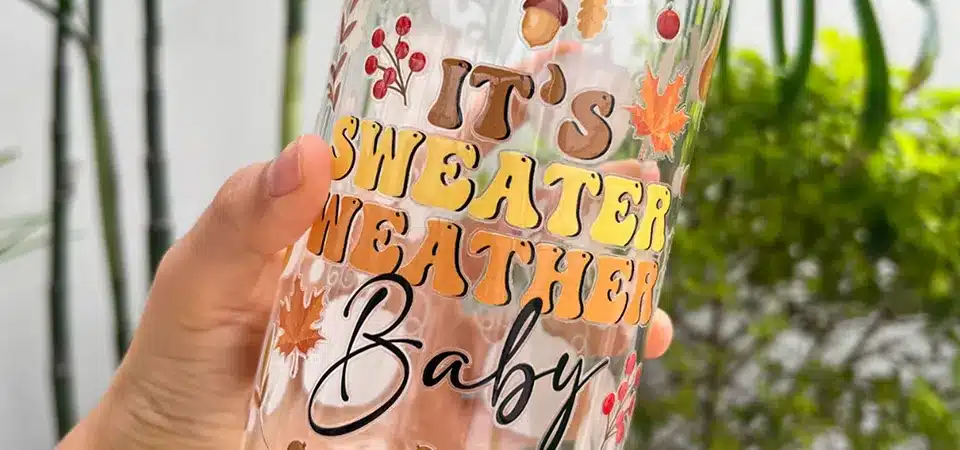 Cold Transfer vs Hot Transfer Application A diagram showing a hand pressing a cold transfer sticker vs. a large heat press machine clamping down on a t-shirt for a hot transfer