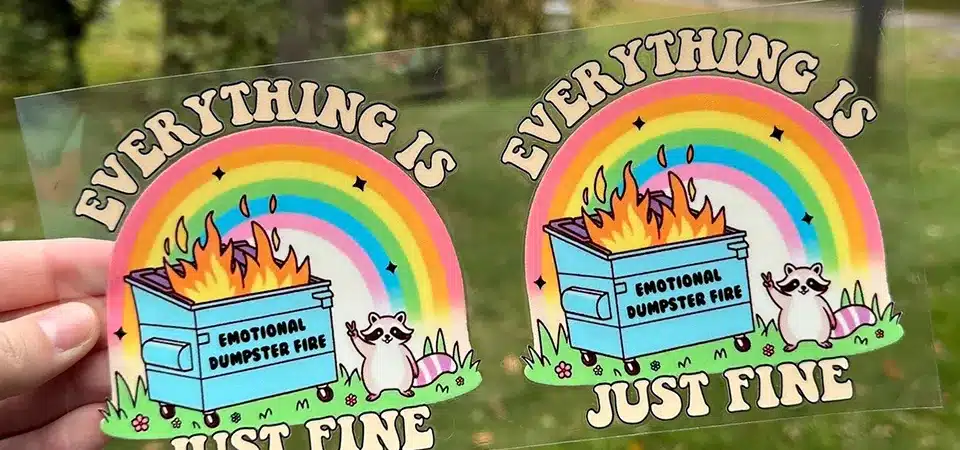 A hand peeling transfer tape back at a sharp 180-degree angle from an applied sticker