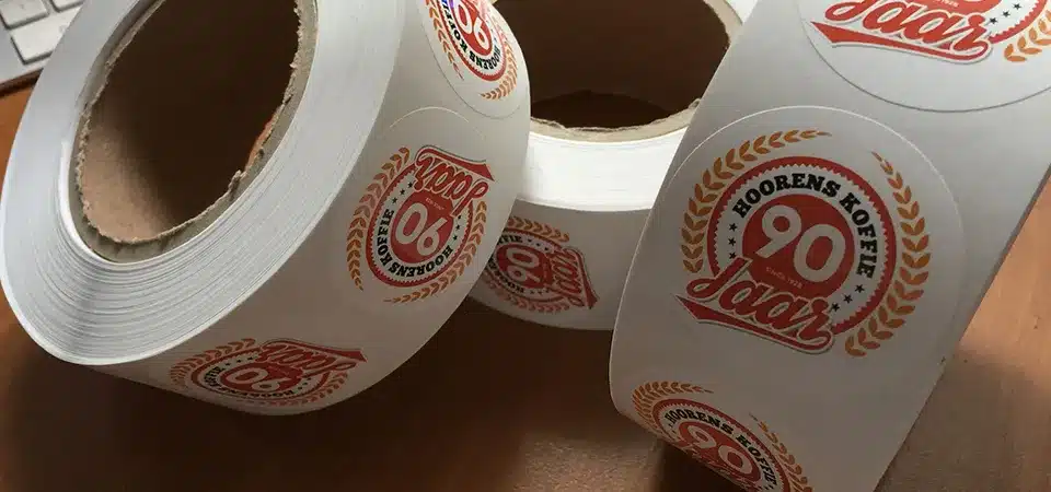 Machine Applying Product Labels A close-up shot of an automated labeling machine applying labels to jars on a conveyor belt