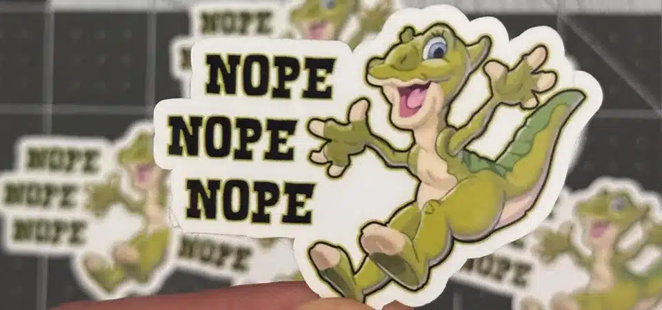 Stickers vs Decals A person applying a large vinyl decal to a wall using a transfer tape