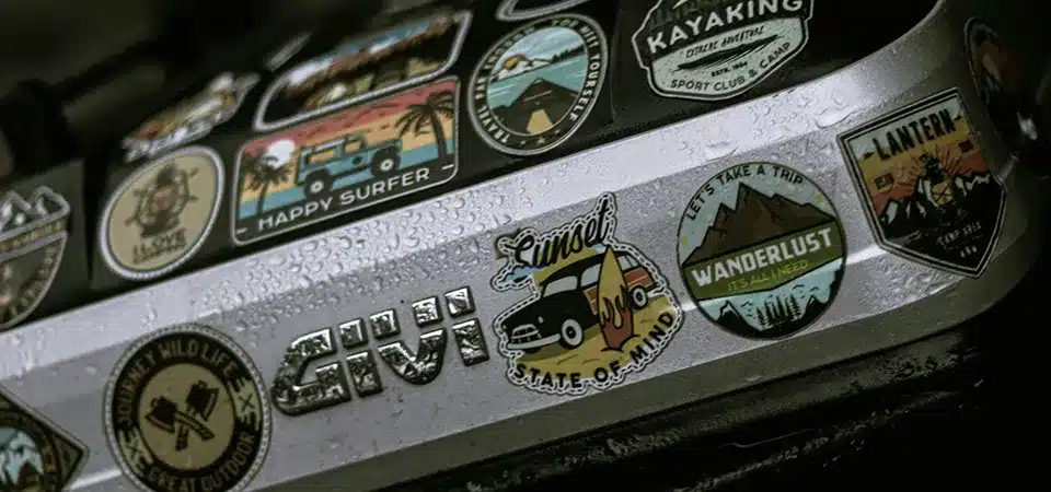 A montage of stickers being used in creative ways: on shipping boxes, as freebies, on laptops