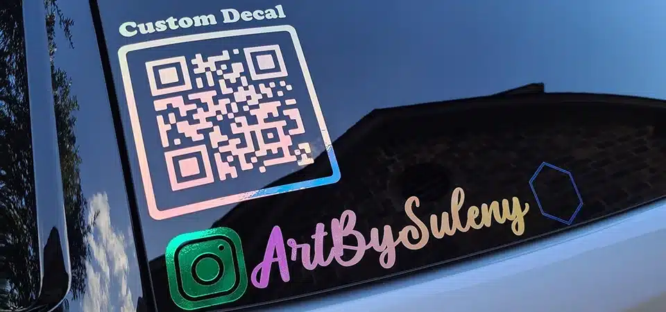 A social media decal with an Instagram logo and handle stuck to a clear cash box at a market stall
