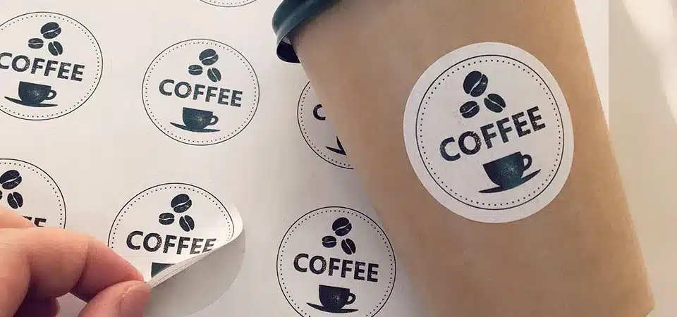 A close-up of a high-quality matte vinyl sticker with a cool logo on a laptop